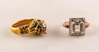 SILVER GILT RING set with an emerald cut pale blue stone above a surround of tiny diamonds, ring