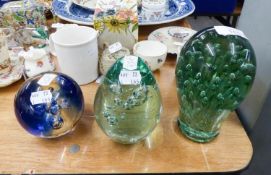 TWO VICTORIAN GREEN GLASS DUMPS, with bubble inclusions, a SIMILAR GLASS PAPERWEIGHT, stained in