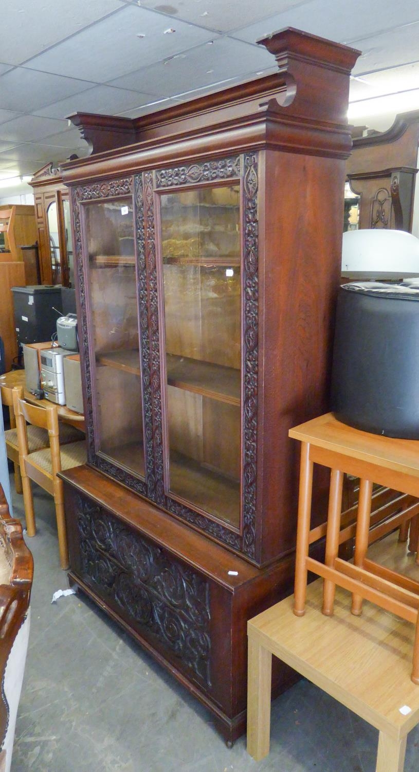 A POSSIBLY WALNUT TWO GLASS PANELLED DOOR DISPLAY CABINET, ABOVE A FALL-FRONT ENCLOSED CUPBOARD