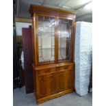 A REPRODUCTION YEW-WOOD LIBRARY BOOKCASE, THE UPPER SECTION HAVING TWO GLAZED DOORS, ABOVE TWO