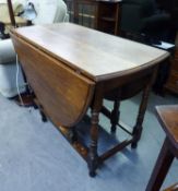 AN OAK OVAL GATELEG DINING TABLE, ON BALUSTER SUPPORTS