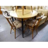 A CIRCULAR KITCHEN DINING TABLE, THE WOOD EFFECT FORMICA TOP EXTENDING WITH A FOLDING LEAF BELOW, 3?