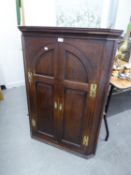 18th CENTURY OAK HANGING CORNER CUPBOARD, ENCLOSED BY A PAIR OF ARCH TOPPED FRAMED PANEL DOORS, WITH