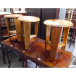 A SET OF THREE SMALL CIRCULAR COFFEE TABLES, EACH ON THREE PROPELLER LEGS, JOINED BY AN UNDER