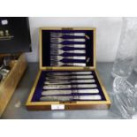 A WALNUT CASE CONTAINING SIX PAIRS OF ENGRAVED ELECTROPLATE FISH EATERS WITH MOTHER OF PEARL HANDLES