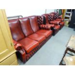 A WINGED LOUNGE SUITE OF THREE PIECES, BUTTON UPHOLSTERED IN OXBLOOD HIDE,  VIZ A THREE SEATER