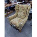 A GOOD QUALITY WINGED FIRESIDE ARMCHAIR, COVERED IN FLORAL FABRIC AND RAISED ON CABRIOLE LEGS