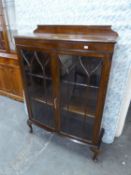 AN OAK DISPLAY CABINET/BOOKCASE WITH TWO GLAZED DOORS, RAISED ON CABRIOLE LEGS