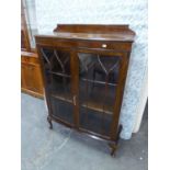 AN OAK DISPLAY CABINET/BOOKCASE WITH TWO GLAZED DOORS, RAISED ON CABRIOLE LEGS