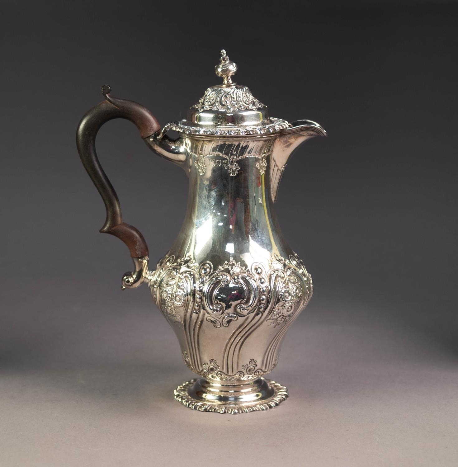 VICTORIAN SILVER PYRIFORM COFFEE POT, repousse with flowers rococo scrolls, the hinged domed lid