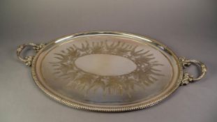 LATE VICTORIAN ELECTROPLATED OVAL GADROON BORDERED TWO HANDLED TEA TRAY, the centre decorated with