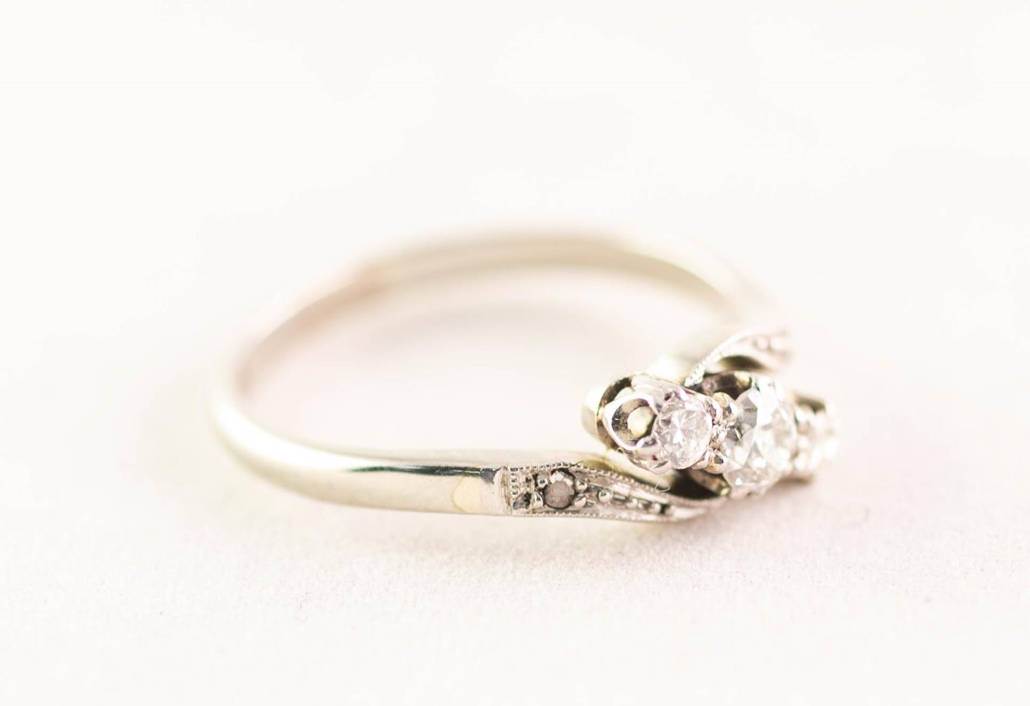 18ct WHITE GOLD AND PLATINUM CROSSOVER RING set with three round brilliant cut diamonds and a tiny - Image 2 of 4