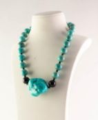 SINGLE STRAND NECKLACE OF LARGE UNIFORM ROUND TURQUOISE BEADS with black bead spreaders and the