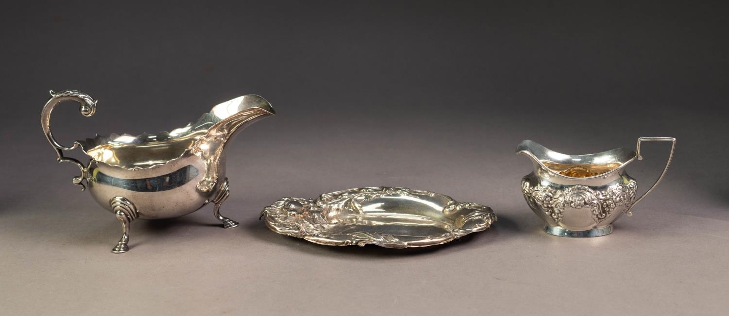 PRE-WAR SILVER SAUCE BOAT with cut rim, leaf capped flying scroll handle and three pad feet,