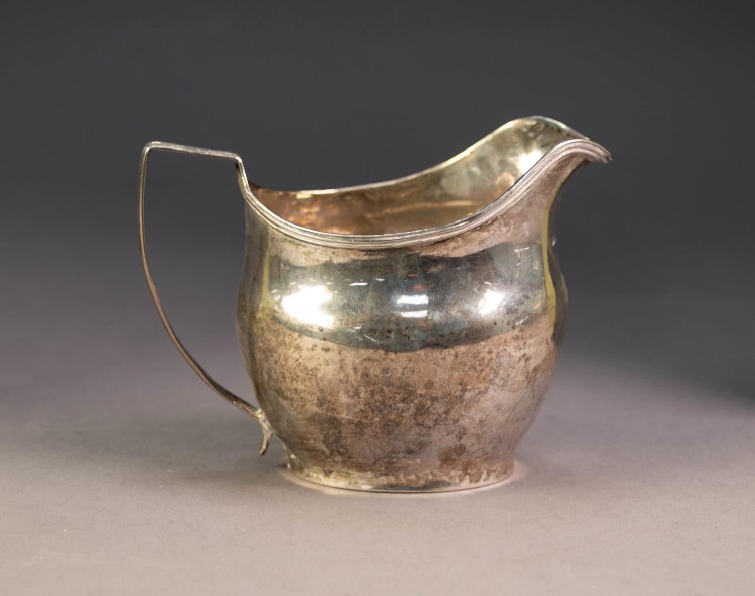 GEORGE III SILVER CREAM JUG BY JOHN MEWBURN, of oval, bellied form with reeded border and angular