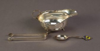 SILVER OVAL SAUCE BOAT, with castellated border, free scroll handle, raised on three hoof feet,
