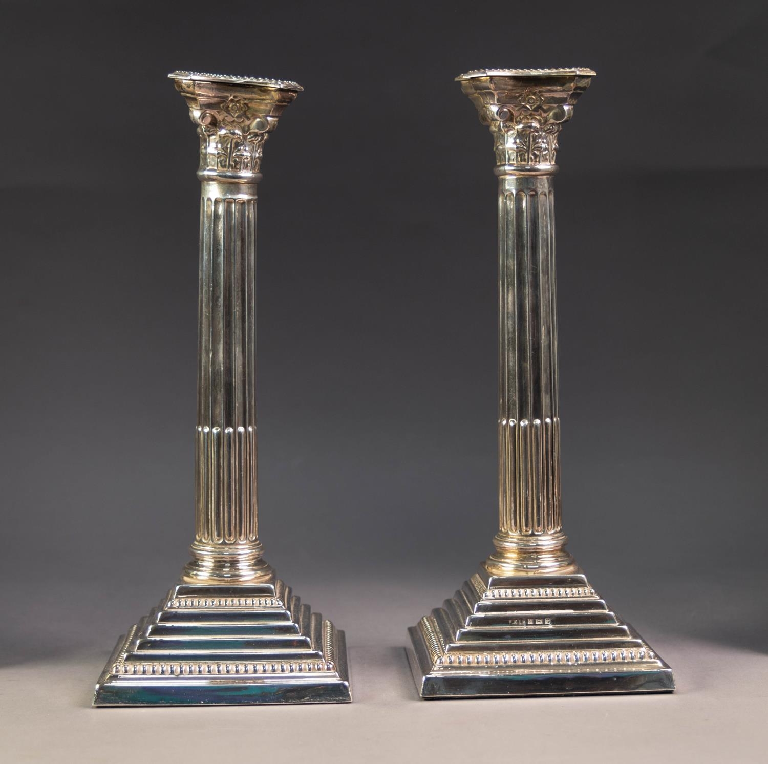 PAIR OF WEIGHTED SILVER CORINTHIAN TABLE CANDLESTICKS, each of part fluted form with removable