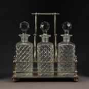 INTER-WAR YEARS ELECTROPLATED DECANTER STAND, with three well-cut square decanters, with carrying