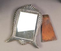 EMBOSSED SILVER FRONTED MIRROR WITH EASEL SUPPORT, the oblong bevel edged plate housed in a scroll