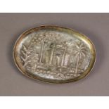 ASIAN EMBOSSED SILVER COLOURED METAL OVAL, SHALLOW DISH, decorated with a temple, figure and palm