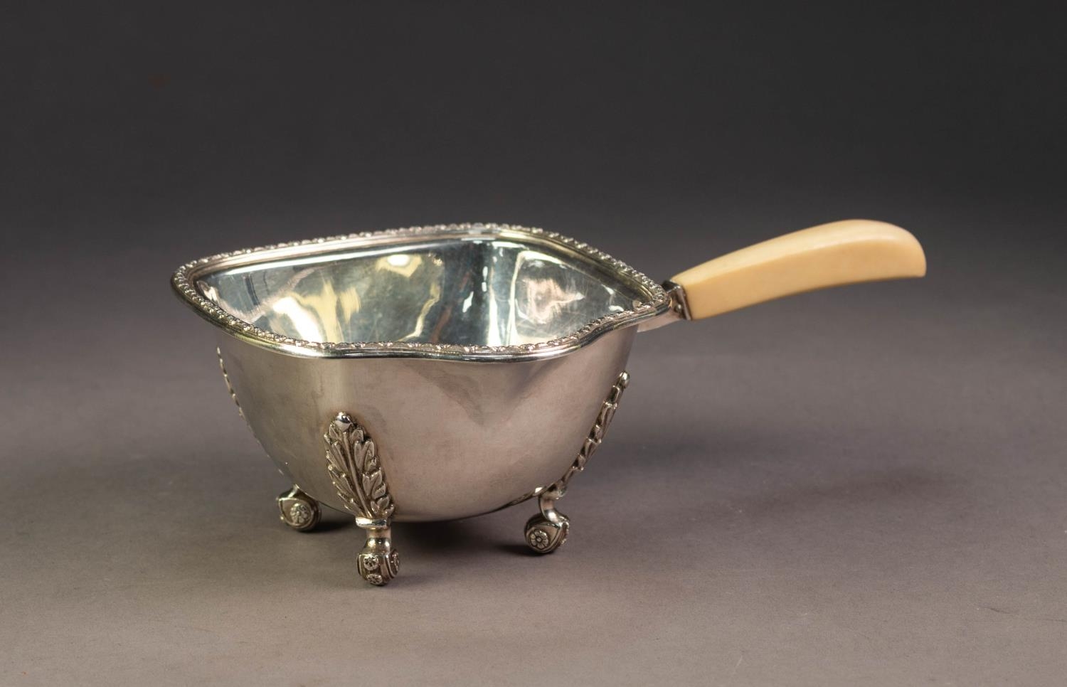 PRE-WAR SILVER BONE HANDLED BRANDY WARMER/POURER with cast floret decorated rim, raised upon four