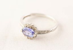 18ct WHITE GOLD RING set with a tanzanite within a surround of ten tiny diamonds, 2.5 gms gross