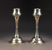 PAIR OF EARLY 20th CENTURY WEIGHTED SILVER ARTS & CRAFTS STYLE CANDLESTICKS, plain waisted girdled