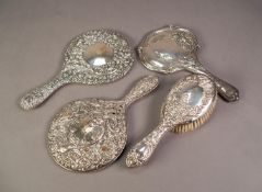 EDWARDIAN SILVER BACK HAND MIRROR, embossed in the Art Nouveau taste, Birmingham 1909; two other