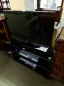 SAMSUNG FLAT SCREEN TELEVISION, ON THREE TIER BLACK GLASS STAND WITH PHILIPS DVD PLAYER AND SHARP
