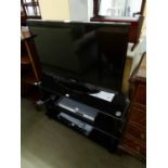 SAMSUNG FLAT SCREEN TELEVISION, ON THREE TIER BLACK GLASS STAND WITH PHILIPS DVD PLAYER AND SHARP