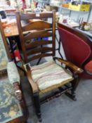 AN ANTIQUE ELM LADDER BACK ROCKING ARMCHAIR, WITH RUSH SEATS