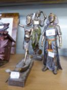 THREE METALLIC FINISH PAINTED COMPOSITION FIGURES OF ANCIENT EGYPTIANS AND A SIMILAR LARGE FIGURE OF