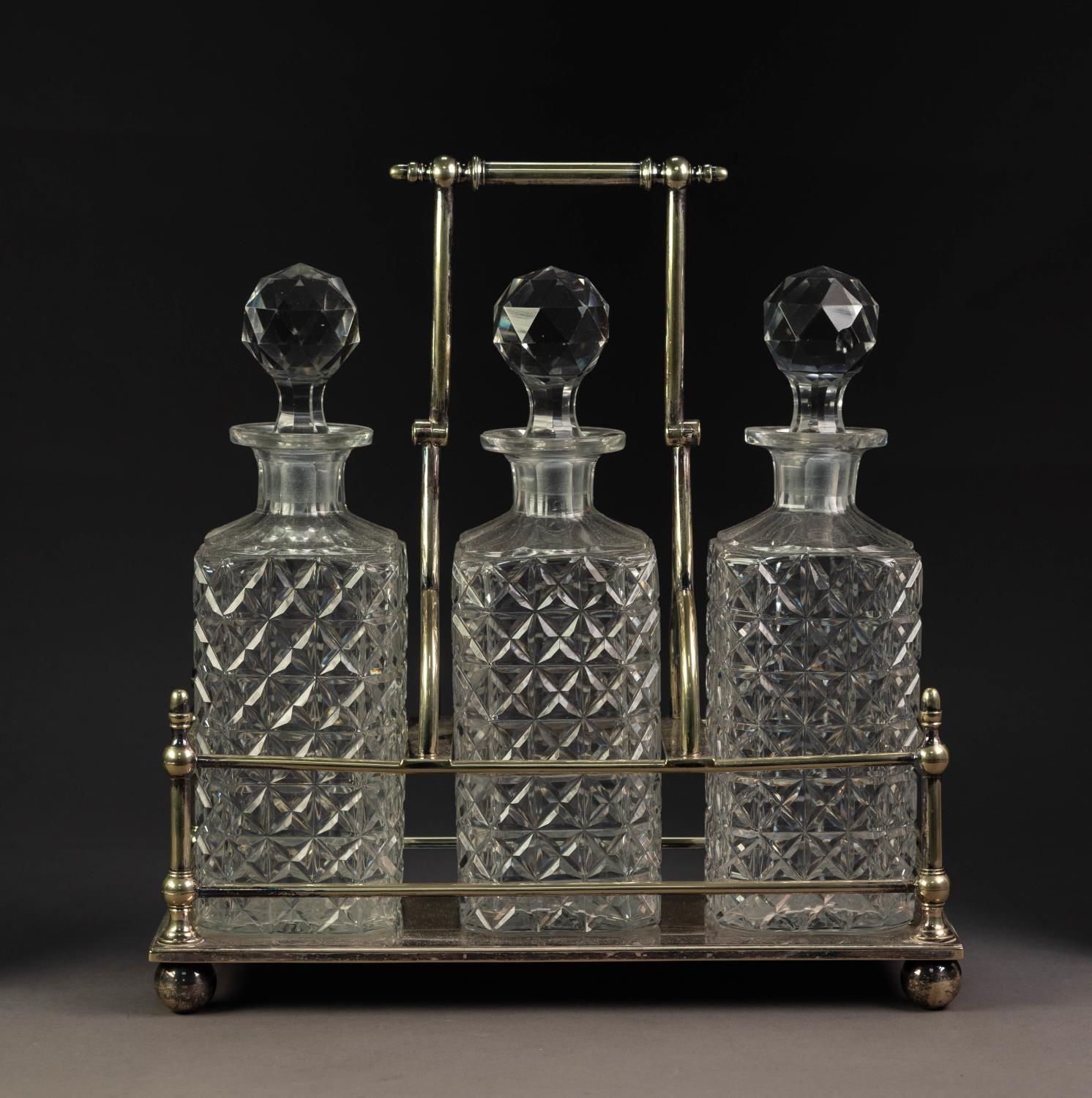 INTER-WAR YEARS ELECTROPLATED DECANTER STAND, with three well-cut square decanters, with carrying