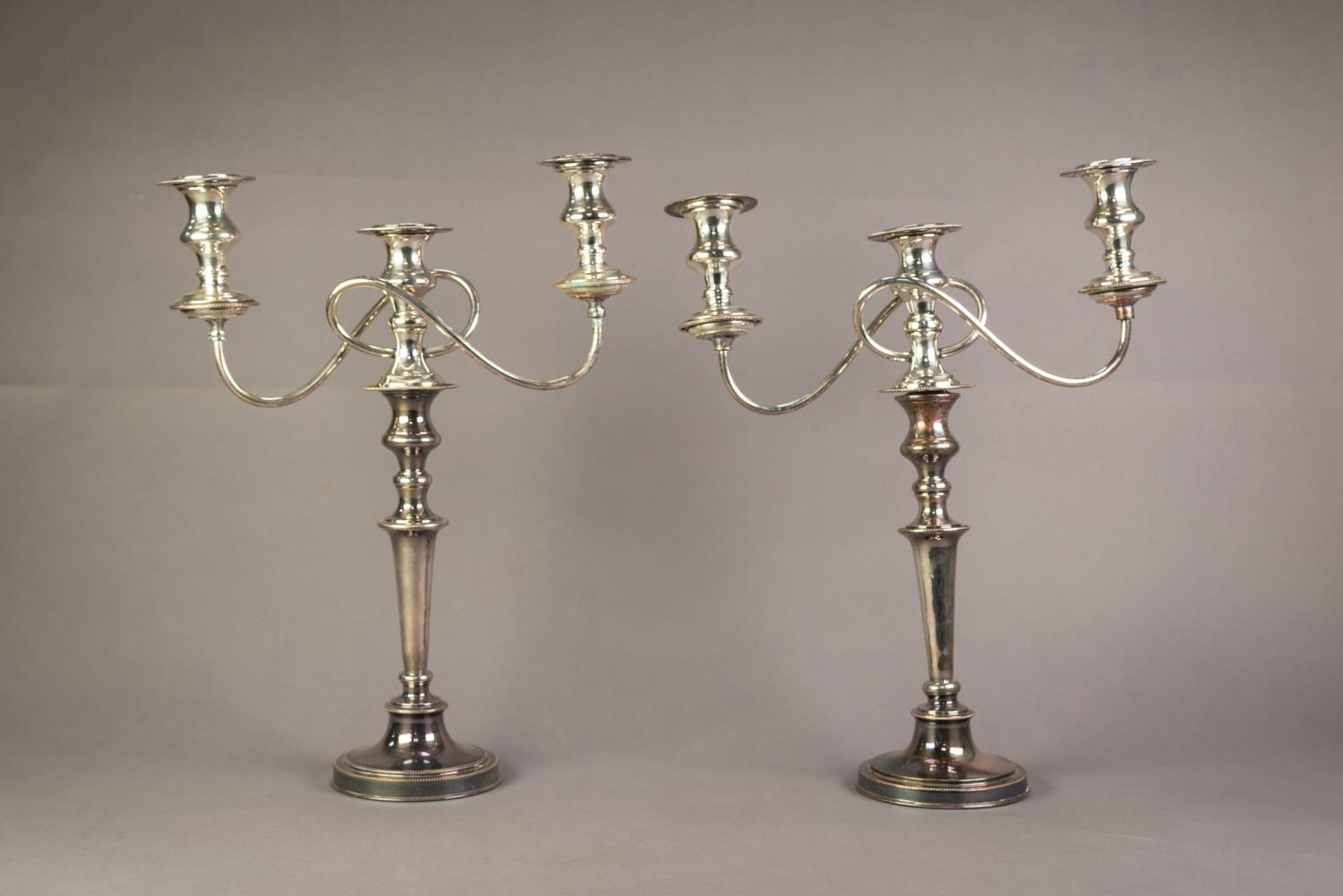 PAIR OF 20th CENTURY ELECTROPLATED CANDLESTICKS with removable three-light twin branch reflex candle