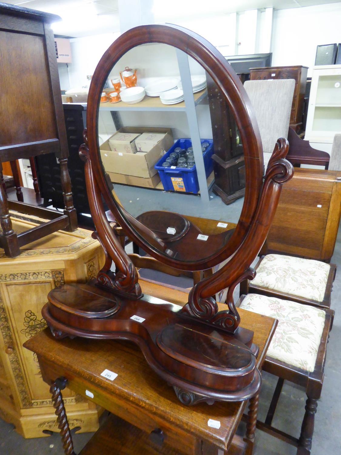 A LARGE VICTORIAN MAHOGANY OVAL SWING TOILET MIRROR, ON KIDNEY SHAPED PLATFORM BASE, WITH TWO LIDDED