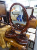 A LARGE VICTORIAN MAHOGANY OVAL SWING TOILET MIRROR, ON KIDNEY SHAPED PLATFORM BASE, WITH TWO LIDDED