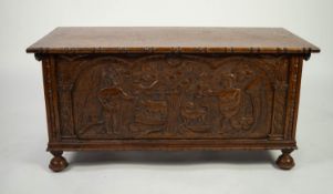 TWENTIETH CENTURY HEAVY CARVED OAK BEDDING BOX, the hinged cover with notched border, set above a