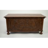 TWENTIETH CENTURY HEAVY CARVED OAK BEDDING BOX, the hinged cover with notched border, set above a