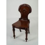 VICTORIAN CARVED MAHOGANY HALL CHAIR, the waisted back with carved border and central roundel, set