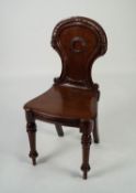 VICTORIAN CARVED MAHOGANY HALL CHAIR, the waisted back with carved border and central roundel, set