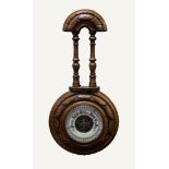 EDWARDIAN CARVED WALNUT ANEROID BAROMETER, with exposed workings to the centre of the 4 ½? dial,