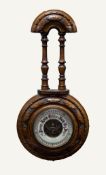 EDWARDIAN CARVED WALNUT ANEROID BAROMETER, with exposed workings to the centre of the 4 ½? dial,