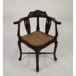 EARLY TWENTIETH CENTURY CARVED MAHOGANY CORNER CHAIR, of typical form with ribbon tied floral