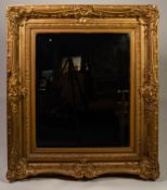 NINETEENTH CENTURY GILT GESSO ?PICTURE FRAME? WALL MIRROR, the later, oblong, bevel edged plate in a