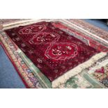 IRANIAN BALOUCHI HAND KNOTTED WOOL RUG, with tulip large medallion pattern on a wine red field