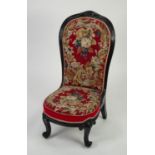 NINETEENTH CENTURY CARVED AND EBONISED NURSING CHAIR, the moulded show-wood frame with floral