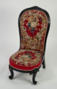 NINETEENTH CENTURY CARVED AND EBONISED NURSING CHAIR, the moulded show-wood frame with floral