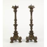 PAIR OF BRASS PRICKET CANDLESTICKS, each of panelled form with triform base and scroll feet,