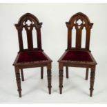 PAIR OF EDWARDIAN CARVED MAHOGANY HALL CHAIRS IN THE GOTHIC TASTE, each with an arched back with