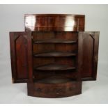 NINETEENTH CENTURY FIGURED MAHOGANY BOW FRONTED CORNER CUPBOARD, with flame cut twin panelled